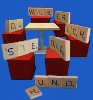 Bild: Scrabble Steine bilden Personalpronomen und sitzen im Stuhlkreis